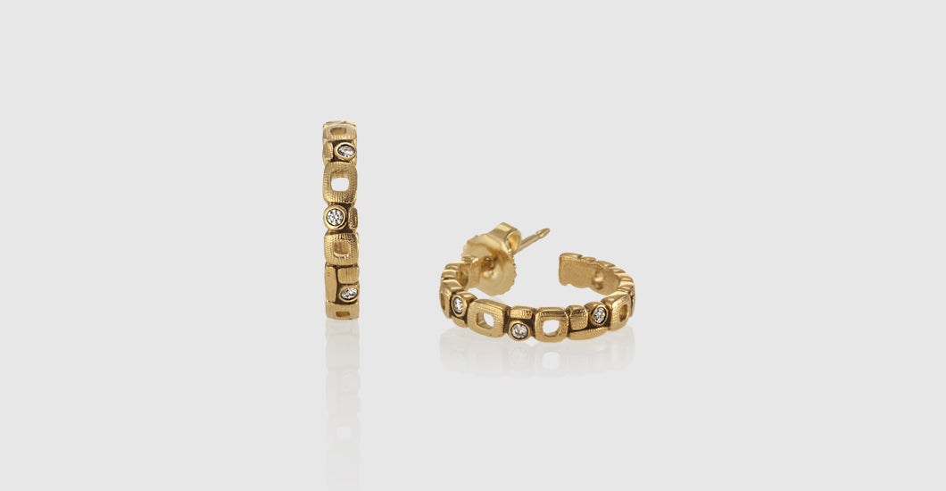 gold and diamond earrings with one laying down