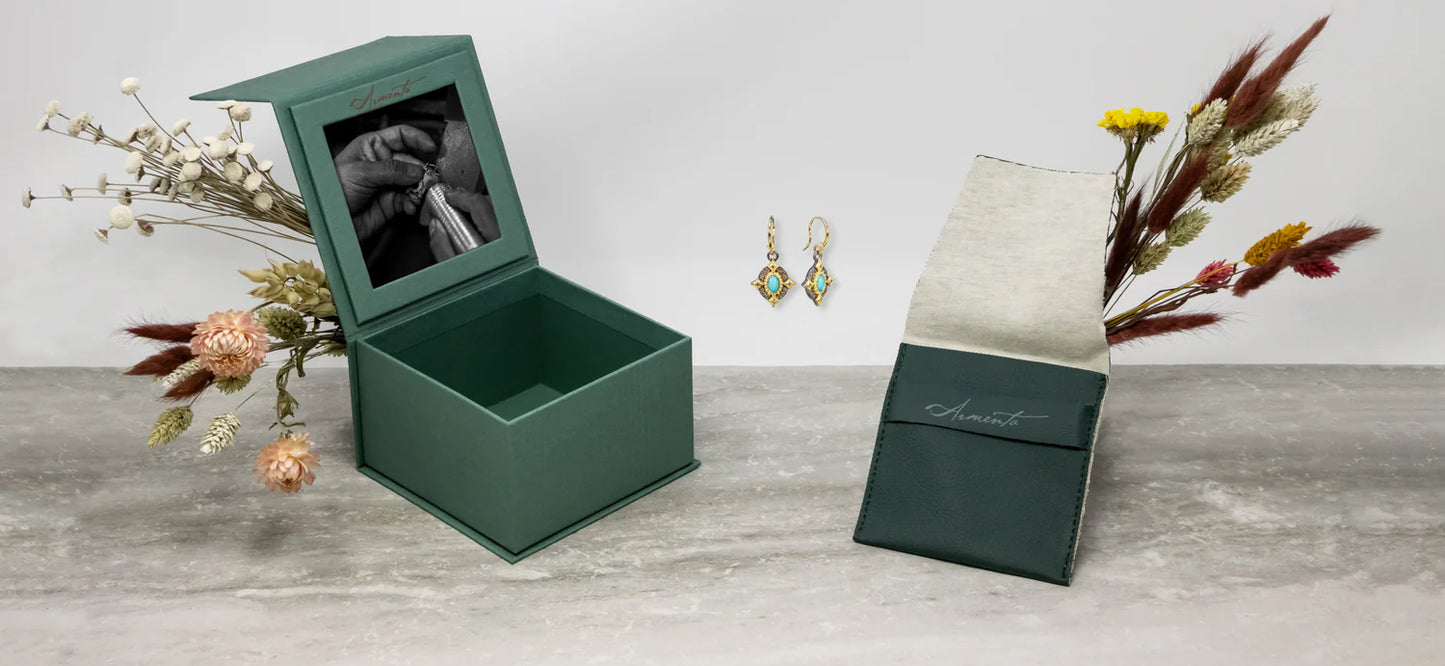 earrings with their box and floral arrangements around