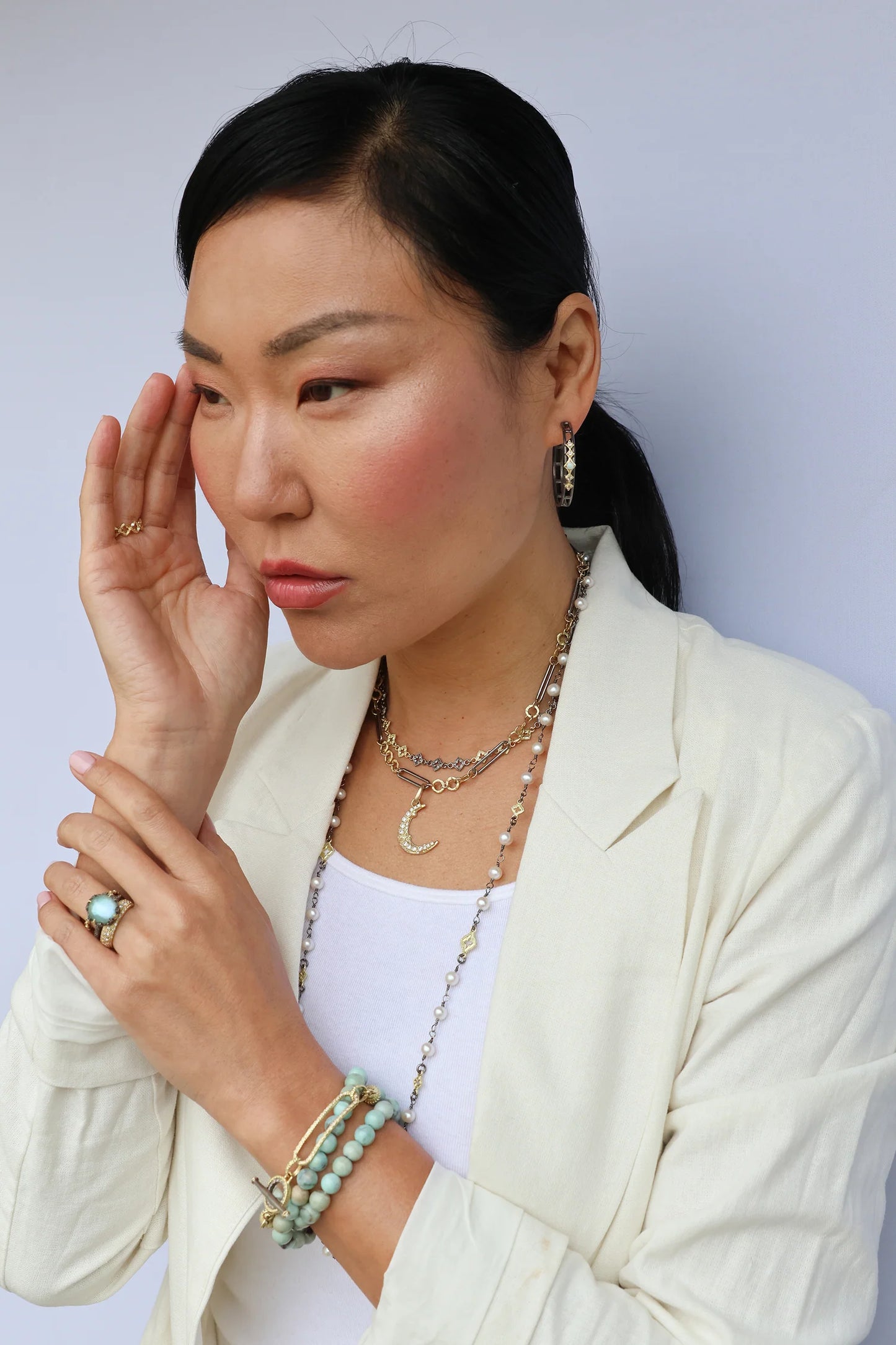 model wearing chain with other pieces of jewelry