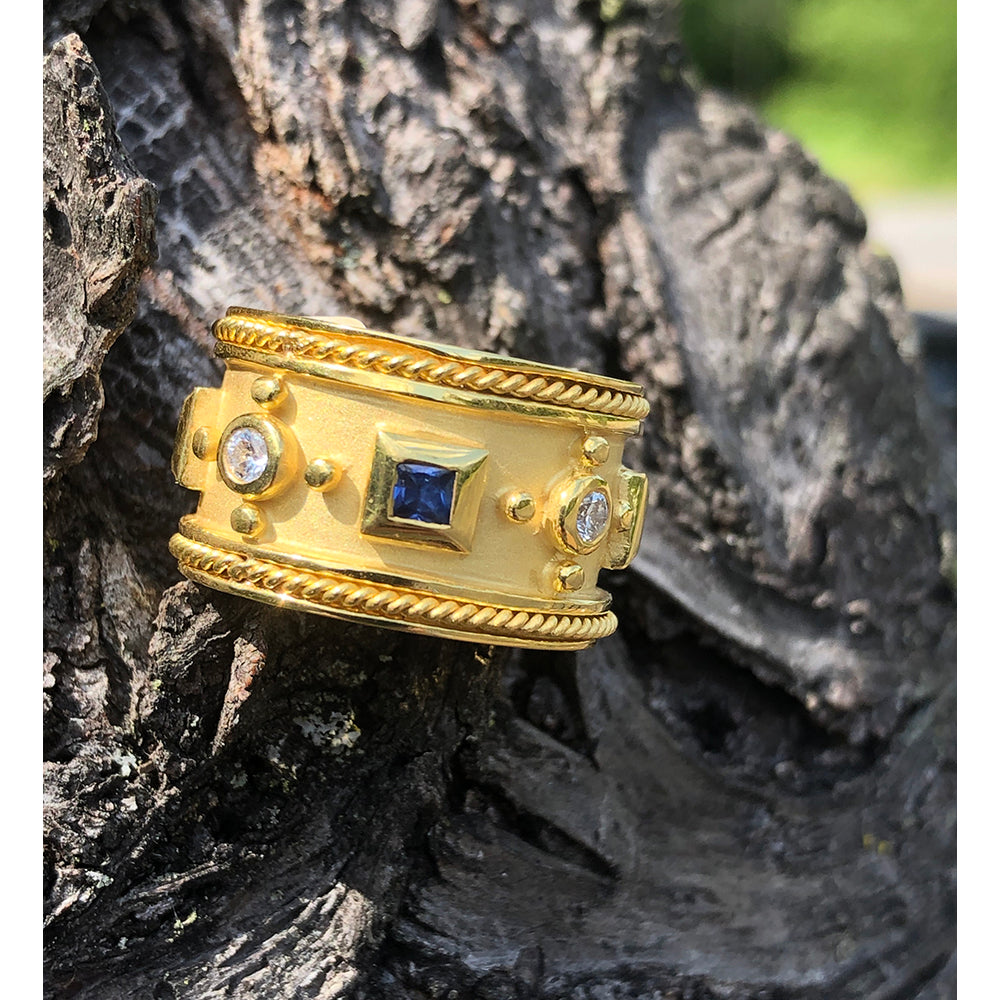 gold ring with diamonds and gemstones with breaded gold on the edges