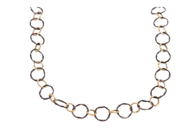 Gold and black chain necklace on a white background