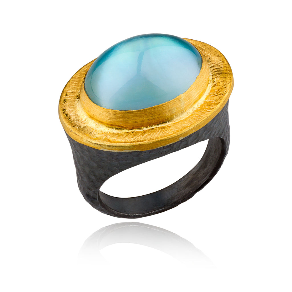 ring with a gemstone in the middle with gold surrounding