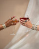 two models wearing bangles and ring while cheers their glasses