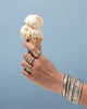 holding an ice cream cone with rings and bangles on hand