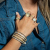 model wearing bangles and rings on fingers